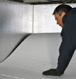 contractor installing TerraBlock™ floor insulation in a Fernley crawl space