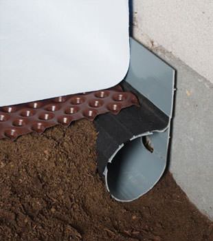 Closeup of a crawl space drainage system installed in Genoa