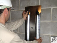 Mounting a foundation wall plate for an earth anchor installation in Minden.