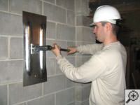 Attempting to straighten a bowed foundation wall by straightening a wall anchor system in a Fernley home.