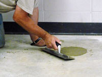 Repairing the cored holes in the concrete slab floor with fresh concrete and cleaning up the Fernley home.