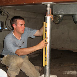 A contractor in Minden installing a crawl space jack post.