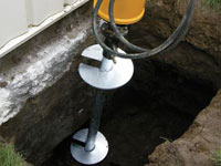 Installing a helical pier system in the earth around a foundation in Sparks