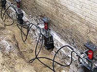 Using foundation push piers to lift a foundation during a repair in Dayton.