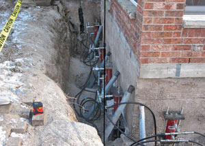 Foundation push piers installed around a house with a foundation settlement issues in Genoa