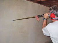 Drilling the hole in the foundation wall for street creep repairs in Tahoma
